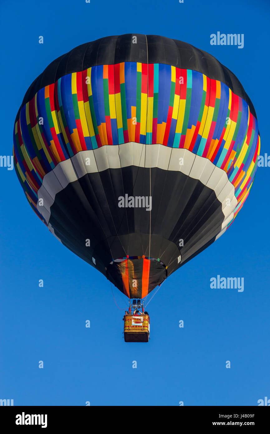 Colored hot air balloon flying in a blue sky Stock Photo - Alamy
