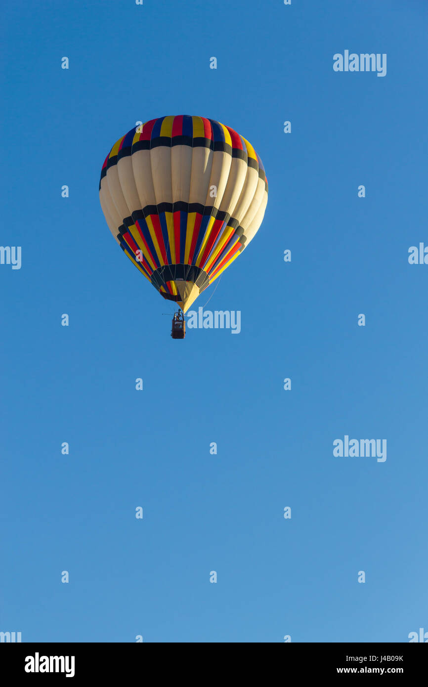 Colored hot air balloon flying in a blue sky Stock Photo - Alamy