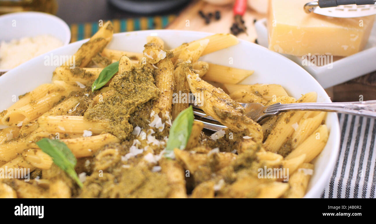 Close up view of Italian pasta (penne) with pesto sauce Stock Photo