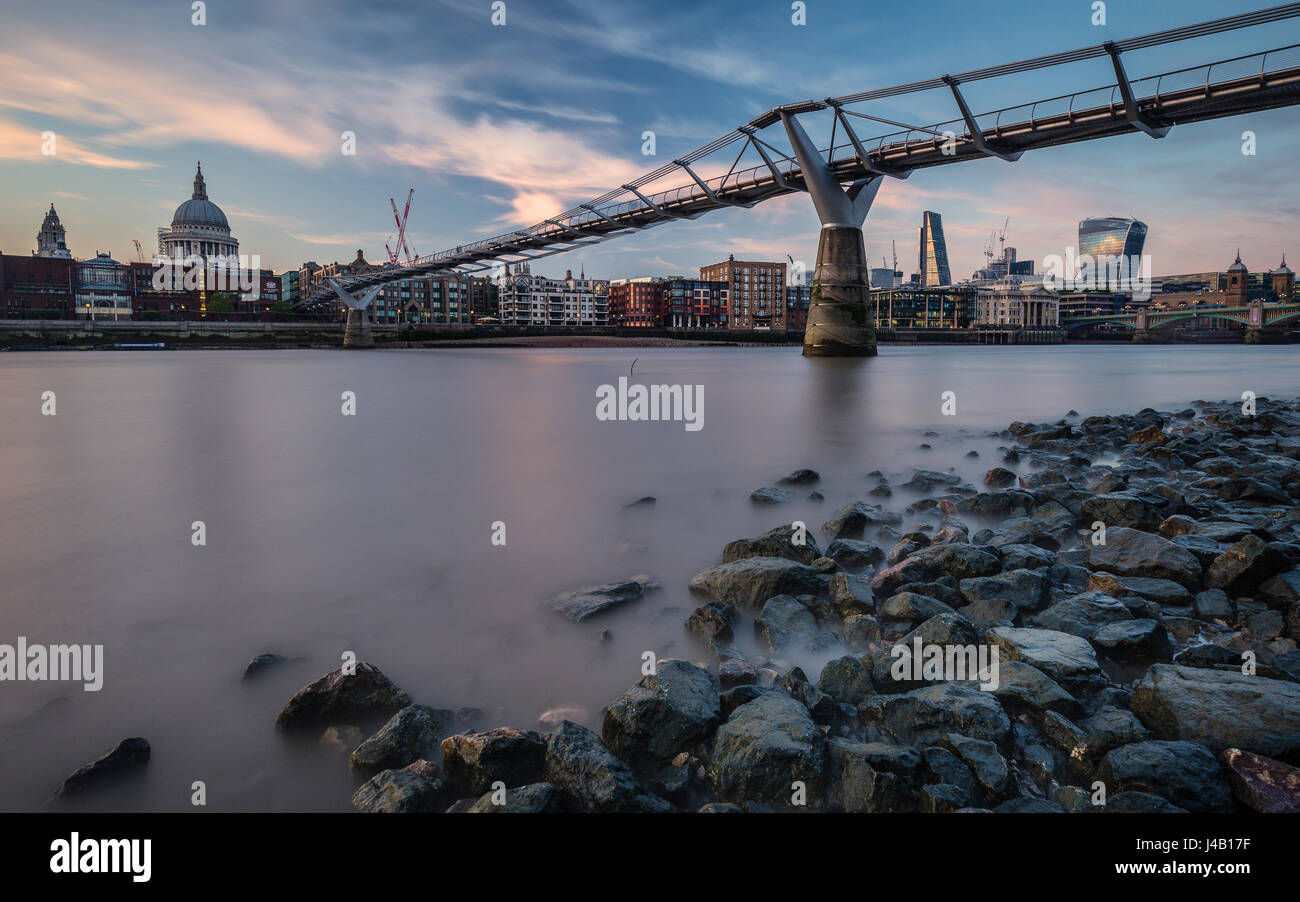 Millennium Bridge with St. Paul and skyline in background during low tide Stock Photo