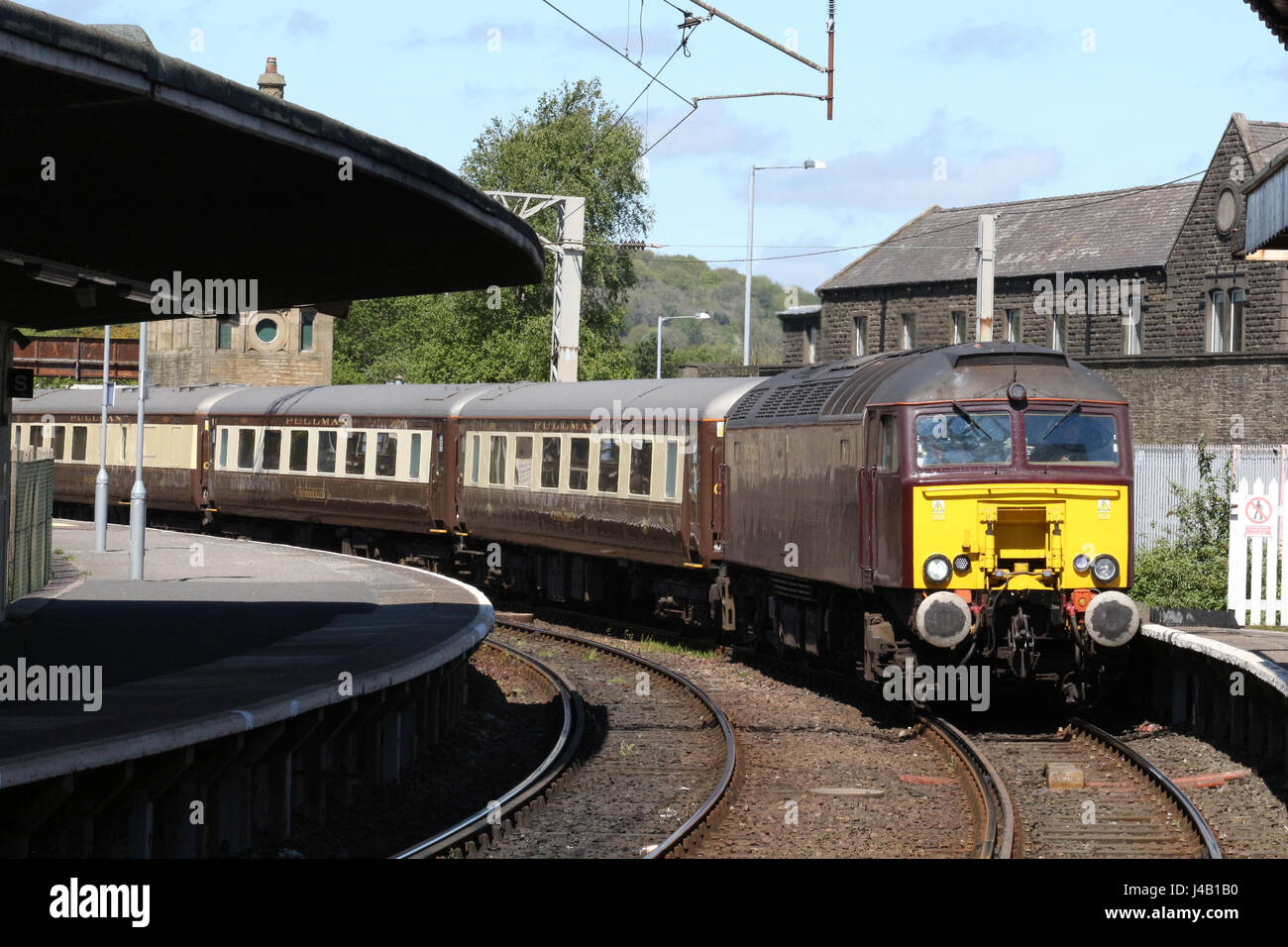 Diesel locomotive in West Coast Railway Company livery hauling empty coaching stock arriving at Carnforth railway station with set of Pullman coaches. Stock Photo