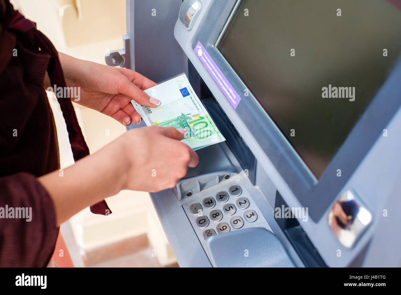 A bundle of money from one hundred euros. Women's hands hold money denominations of 100 euros. Cash out money at an ATM Stock Photo