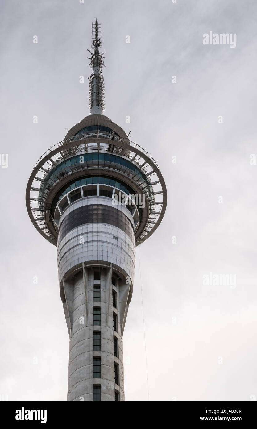 Auckland, New Zealand - March 5, 2017: Closeup of tall communication and restaurant Sky Tower top under gray sky. Stock Photo