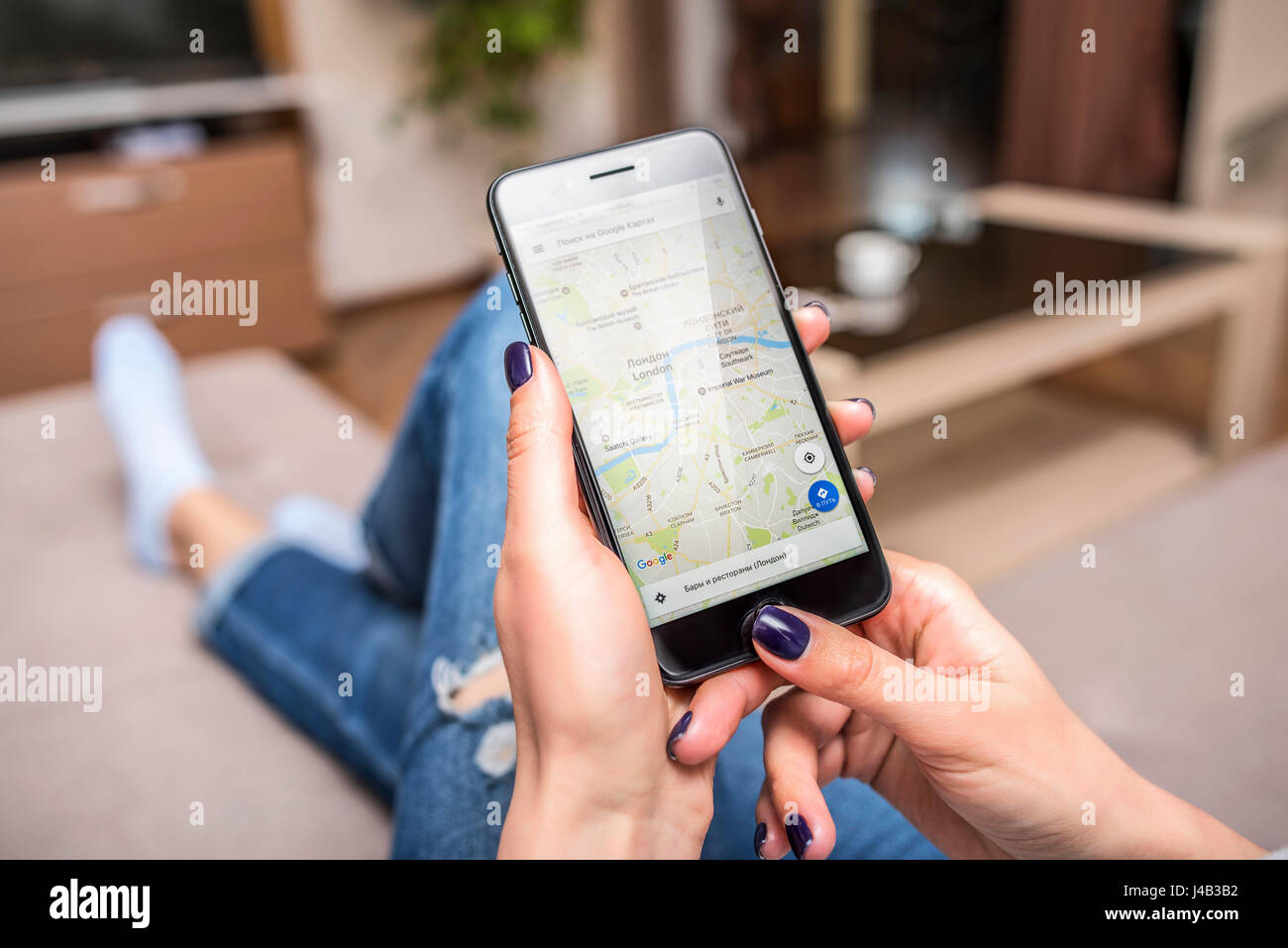 Black iPhone 7 Plus with Google Maps in hands. Stock Photo