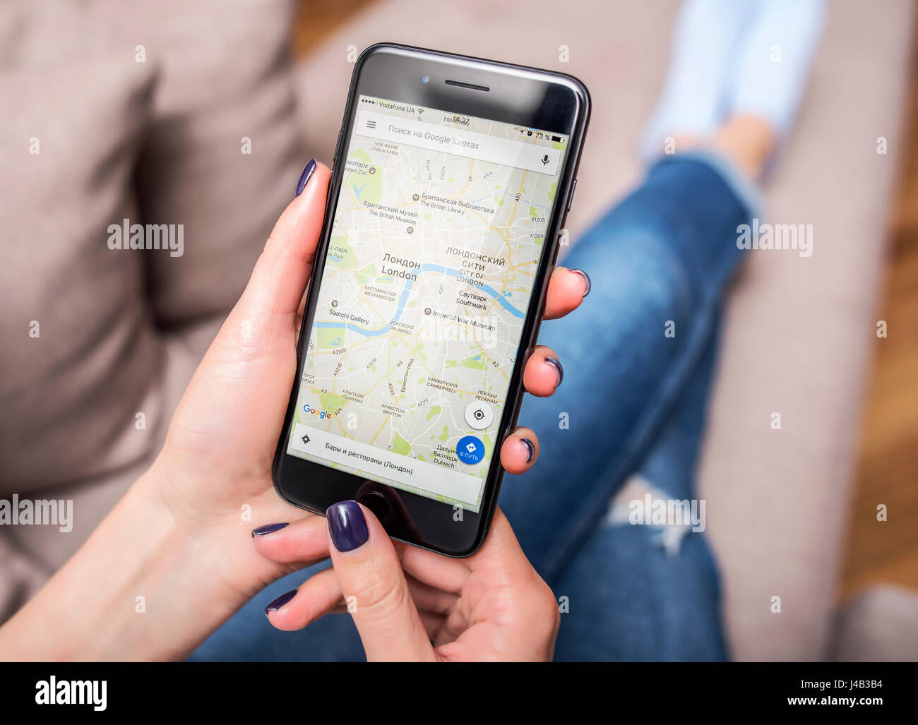 Black iPhone 7 Plus with Google Maps in hands. Stock Photo