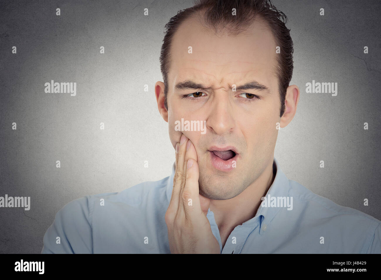 Closeup portrait headshot young man with sensitive tooth ache crown