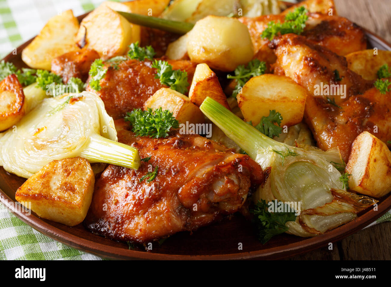 Spicy chicken baked with fennel and potatoes closeup on a plate