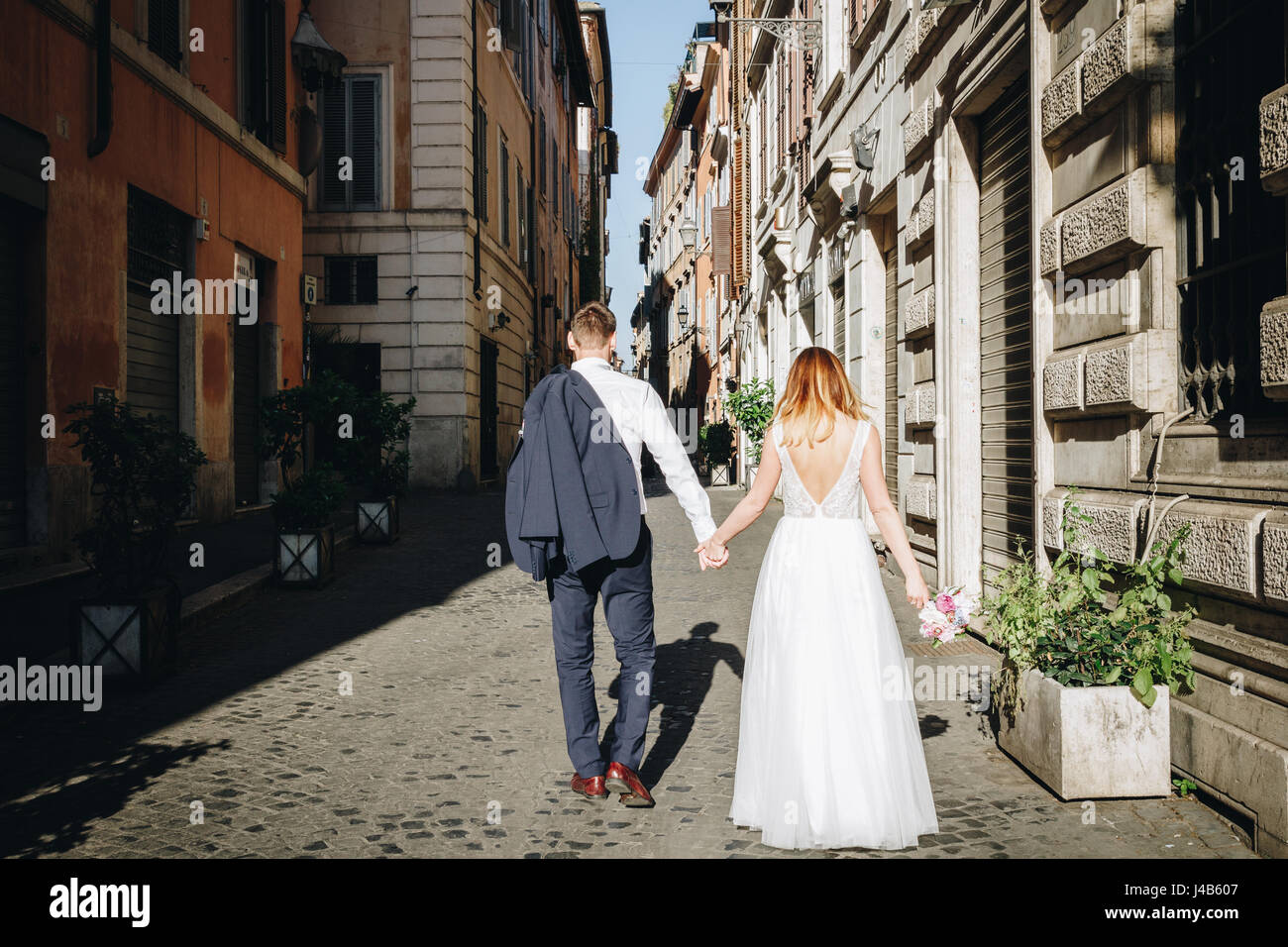Bride and groom posing on the old streets of Rome, Italy Stock Photo ...