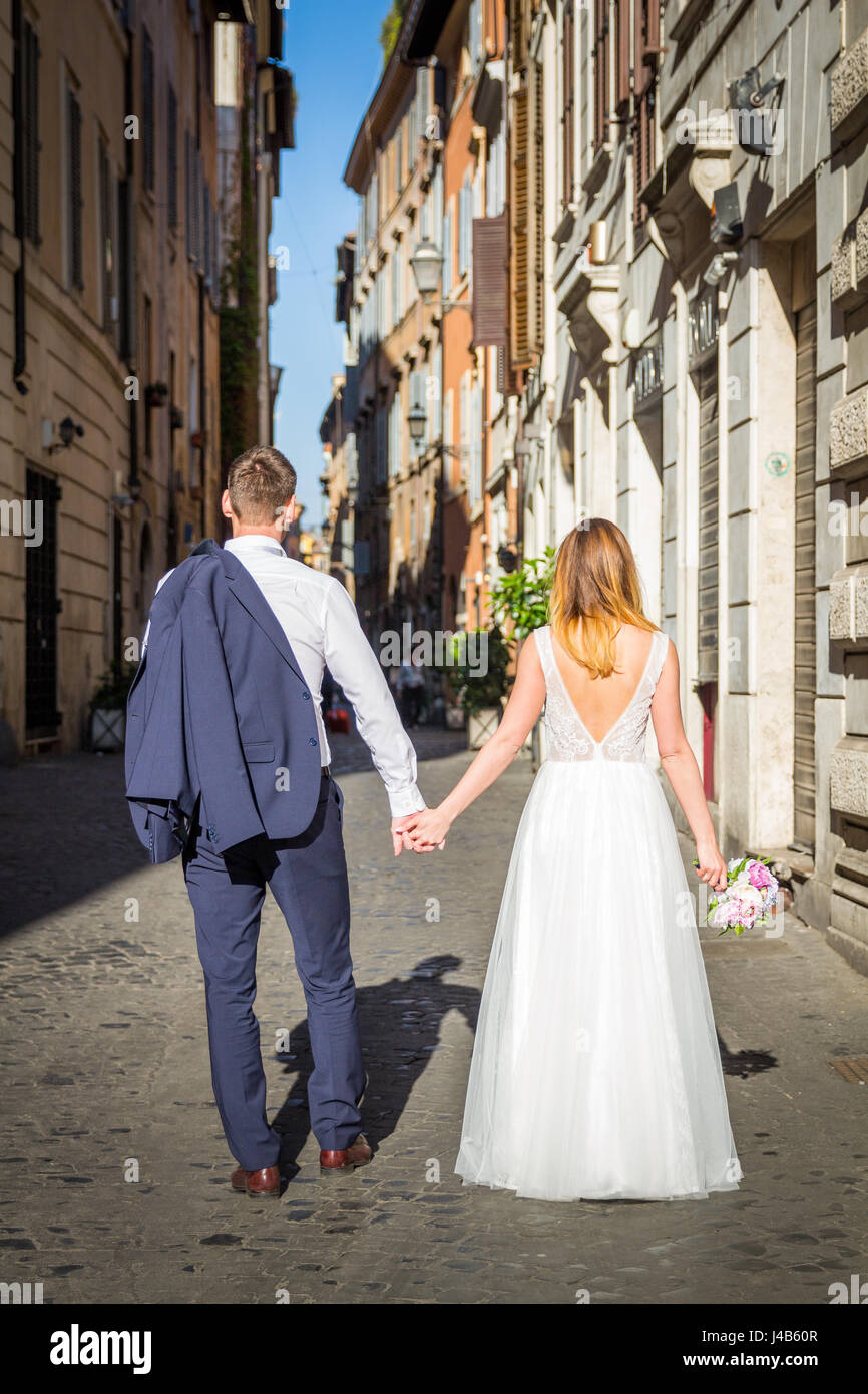 Bride and groom posing on the old streets of Rome, Italy Stock Photo ...