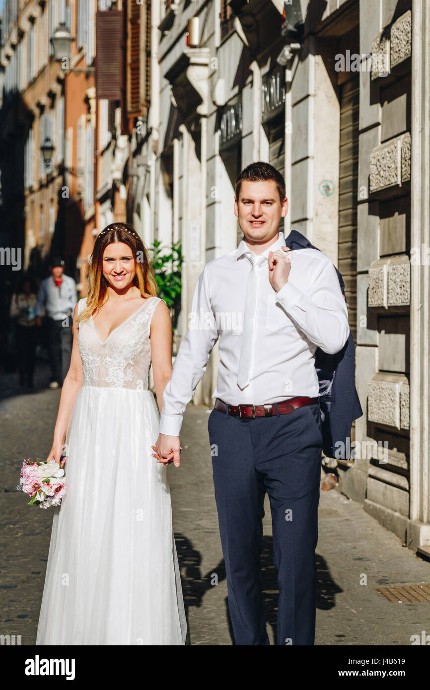 Bride and groom posing on the old streets of Rome, Italy Stock Photo ...