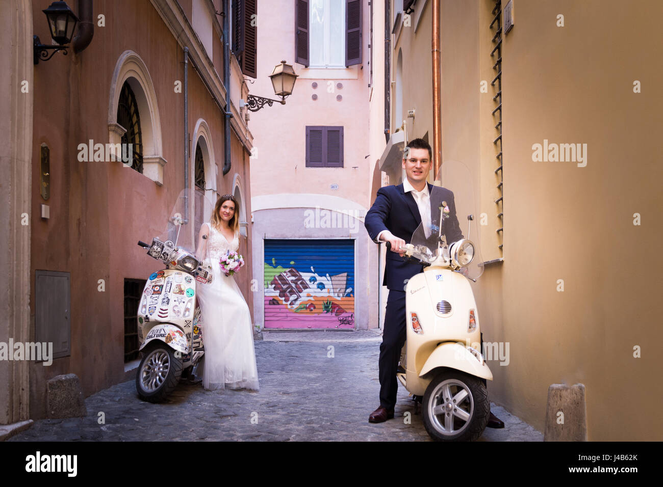 Young beautiful bride and groom on the wedding walk through the streets of old Rome, Italy. Stock Photo