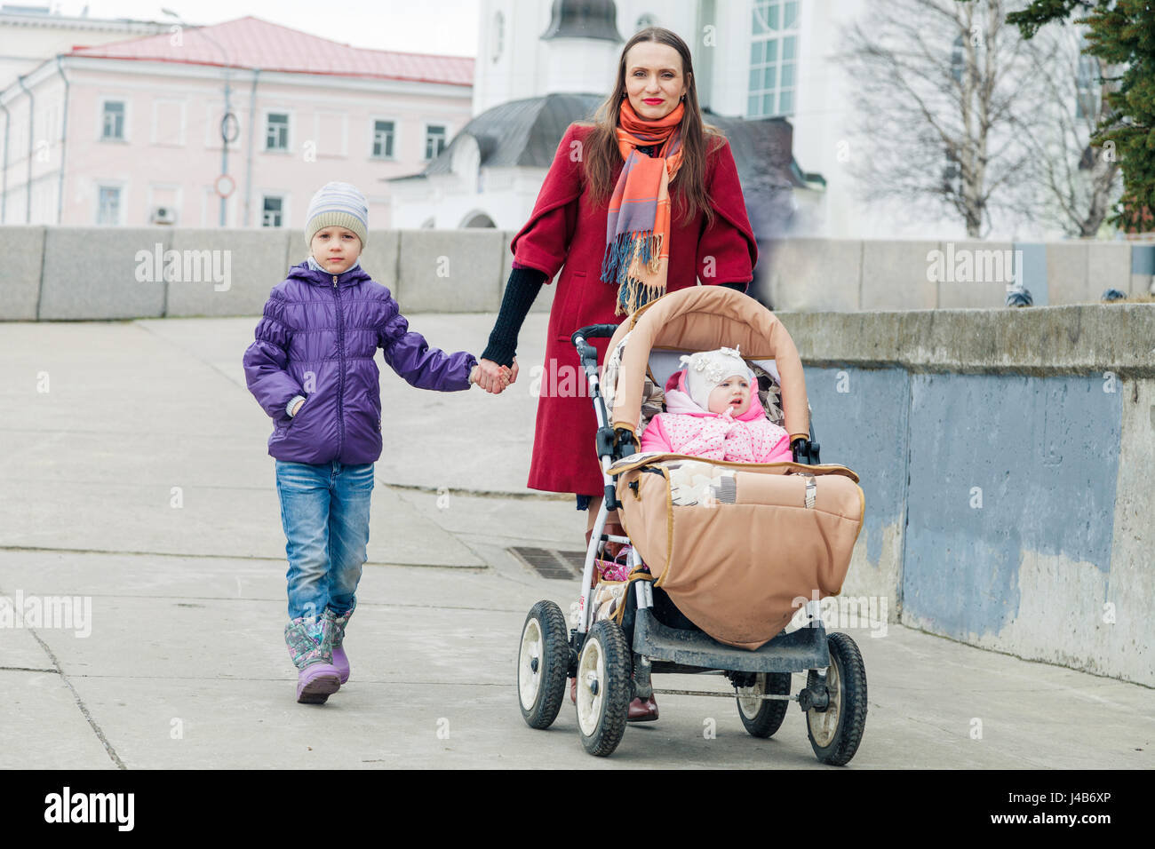 Happy mother walks with two daughters Stock Photo