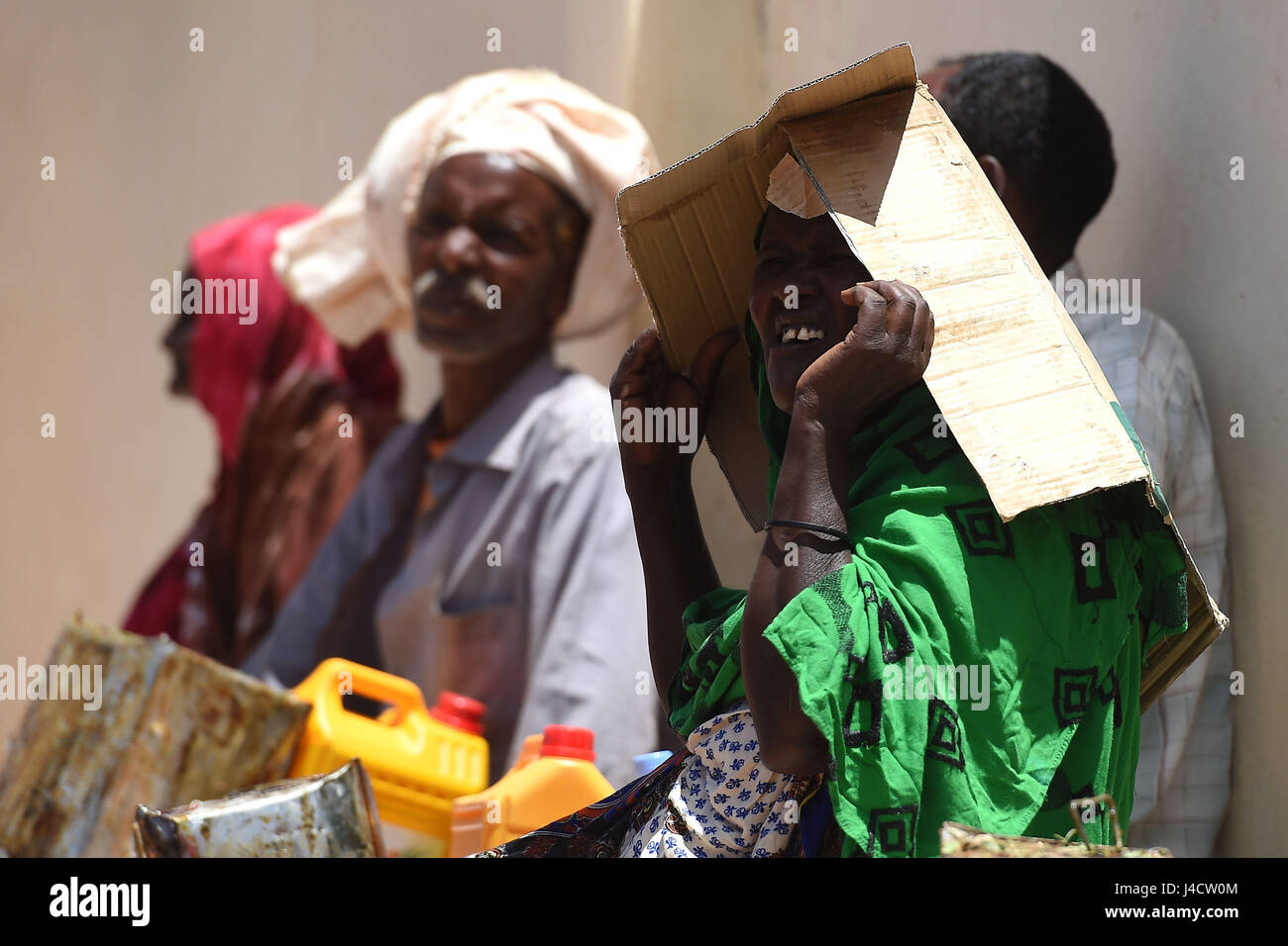 Villagers wait for their their food distribution of rice, sugar, dates and palm oil from charity Action Aid in Sayla Bari, Somaliland. Stock Photo