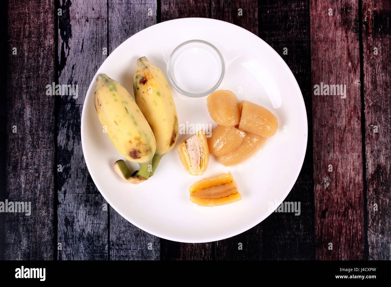 Thai popular dessert, Ready served of boiled banana in syrup and wholes of banana with coconut milk. Stock Photo