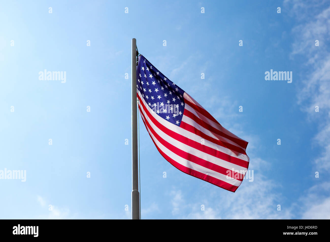 Flag of United States on a flagpole in front of blue sky Stock Photo ...