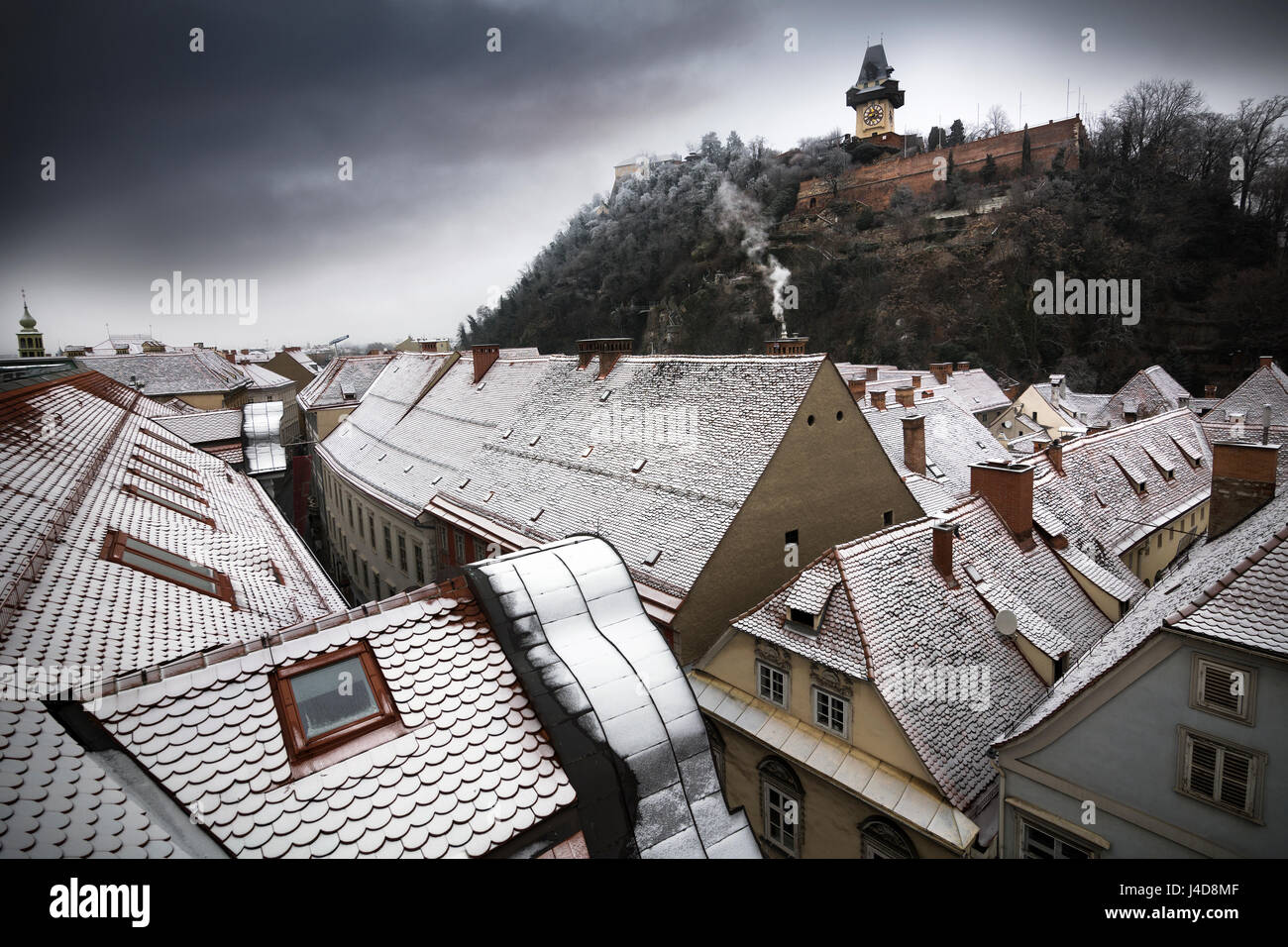 Snowy rooftops in Austrian city of Graz with landmark clocktower Stock Photo