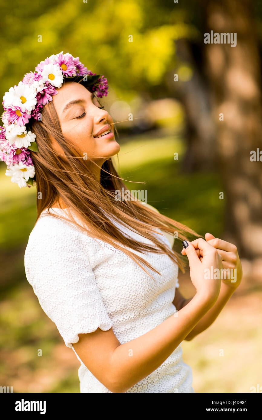 Pretty young woman with flowers in her hair on sunny spring day Stock ...