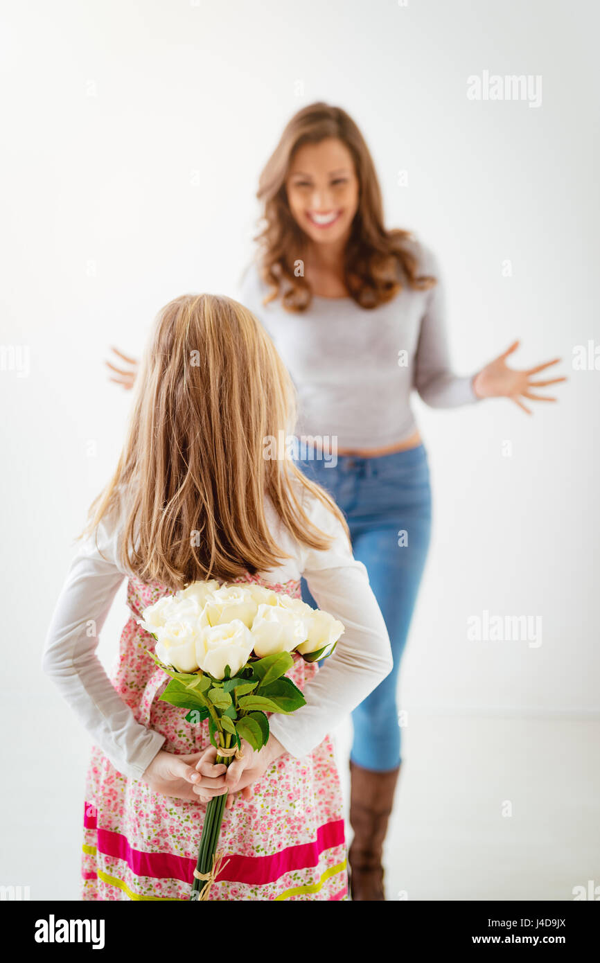 Cute daughter giving her mother bouquet white roses for Mother's Day