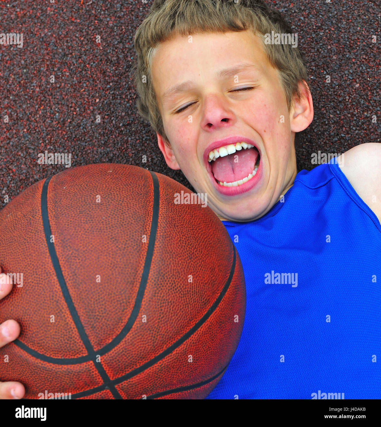 Basketball player with the open mouth lying on the court Stock Photo
