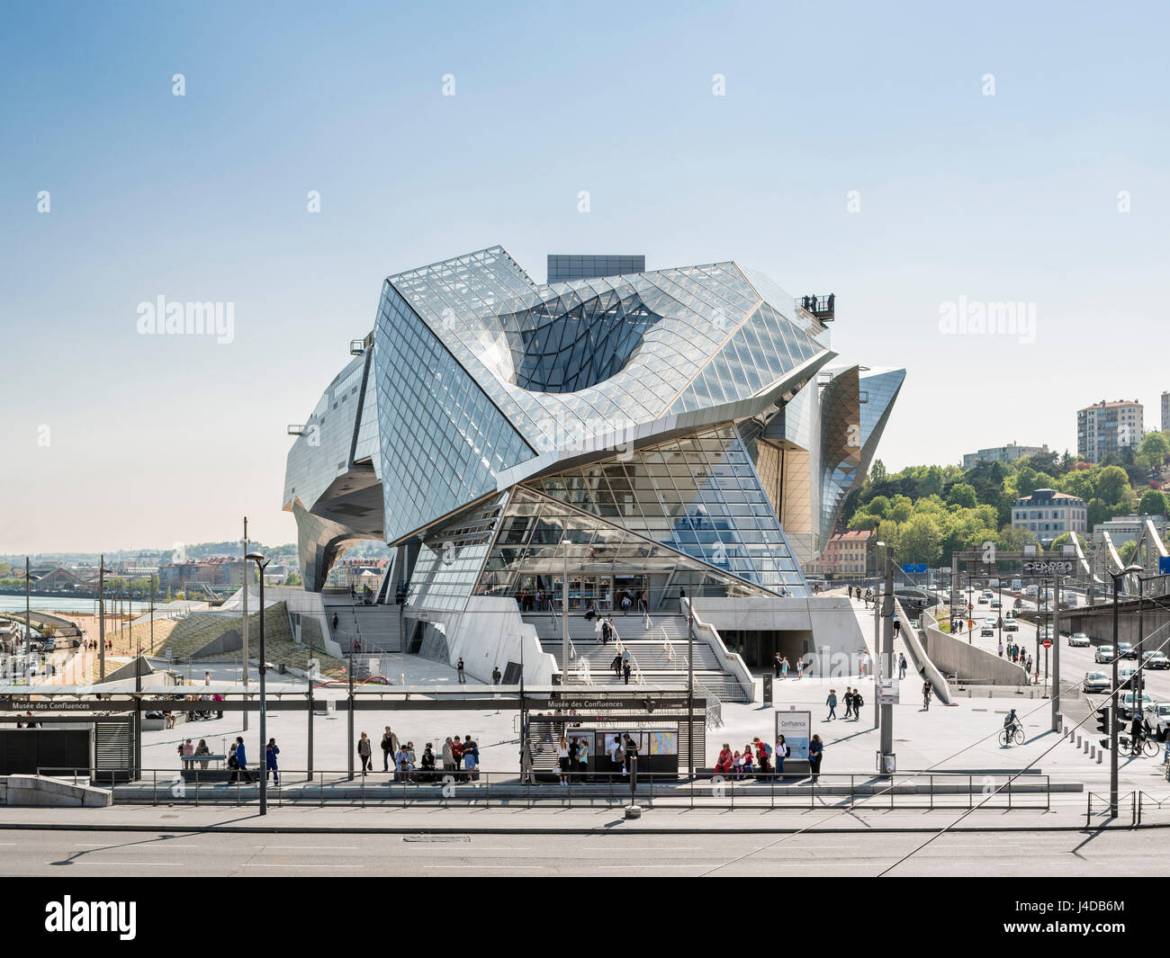 Exterior view from the north with the stairs leading to the entrance and a tram stop on Pont Pasteur. Musée des Confluences, Lyon, France. Architect: Stock Photo