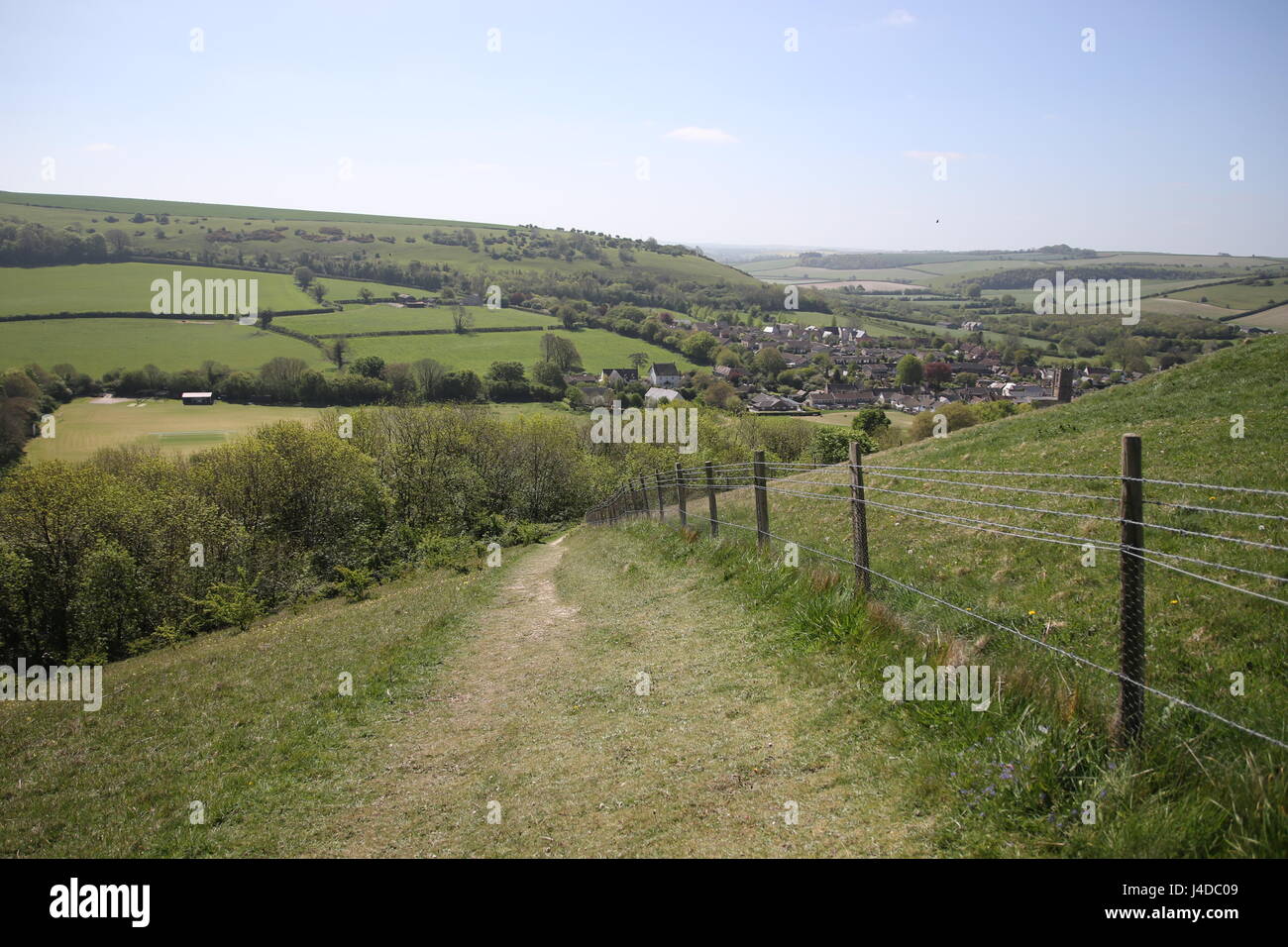 Looking down from a hill and along a footpath to the scenic and historic village of Cerne Abbas in Dorset, England Stock Photo