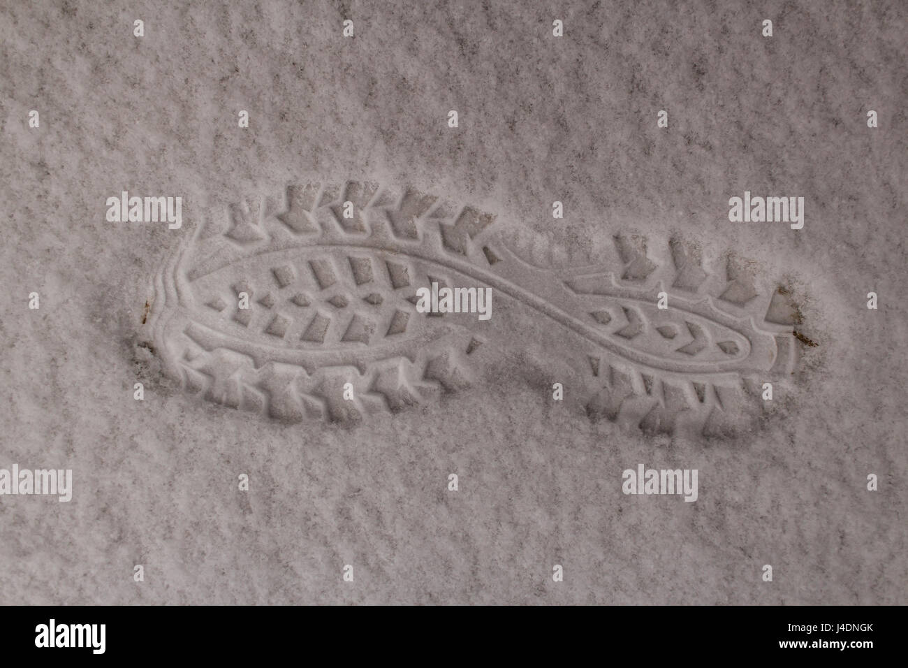 Footprint of the boot on white clear snow. Snow is very fluffy. Winter returned at the end of March. Stock Photo