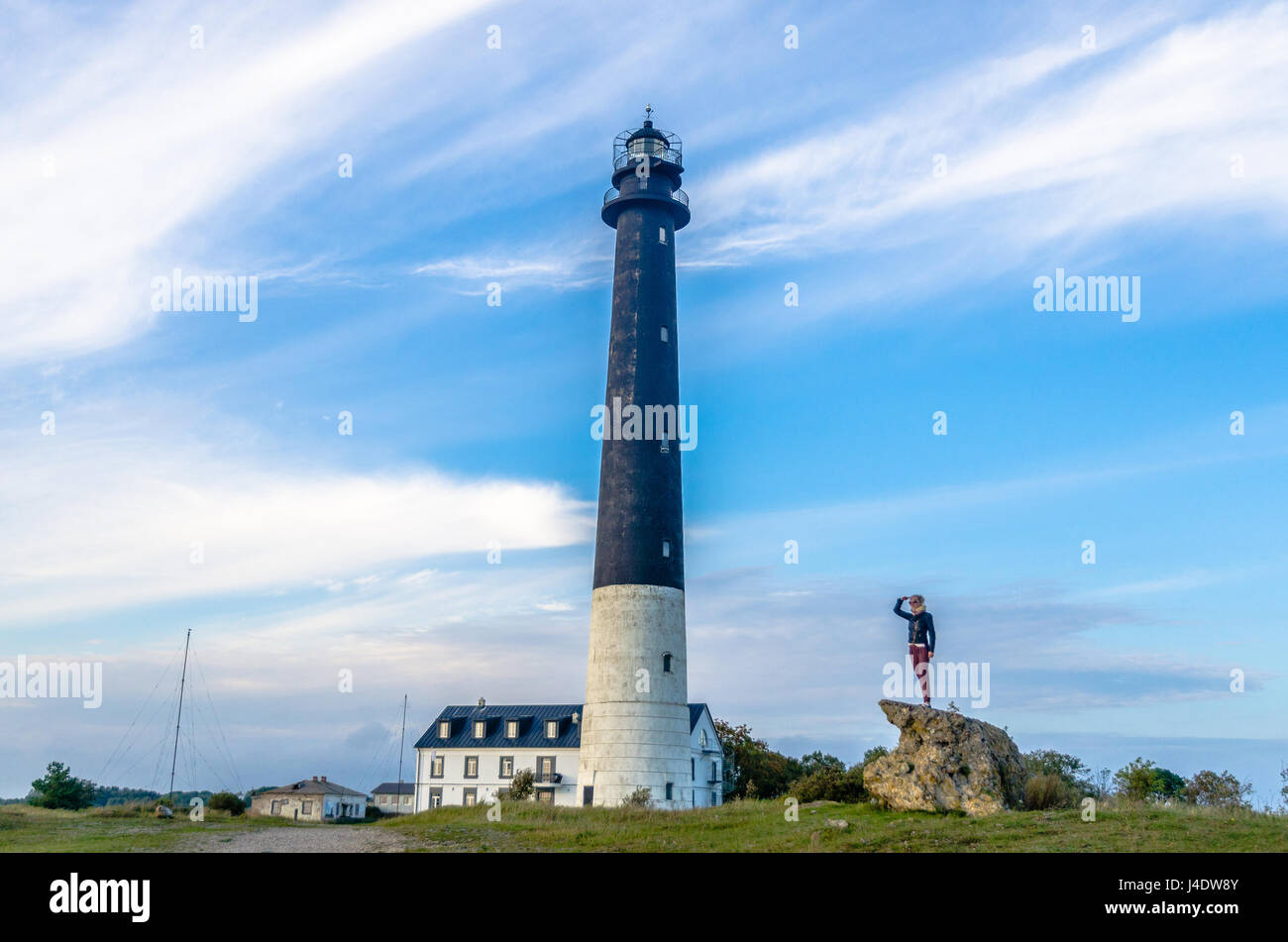 Woman standing and the Sõrve Lighthouse Stock Photo