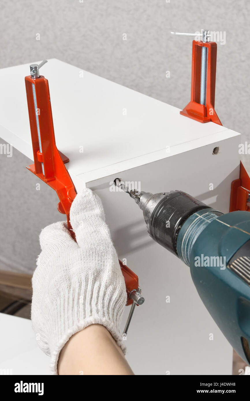 hands drilling a hole during assembling of furniture Stock Photo
