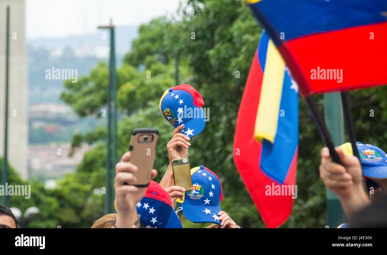 Venezuelans lift the caps with the flag of Venezuela at the end of listening to the national anthem. Musicians and artists marched in homage to the dead in the protests in Caracas. Venezuela. May,7,2017 Stock Photo