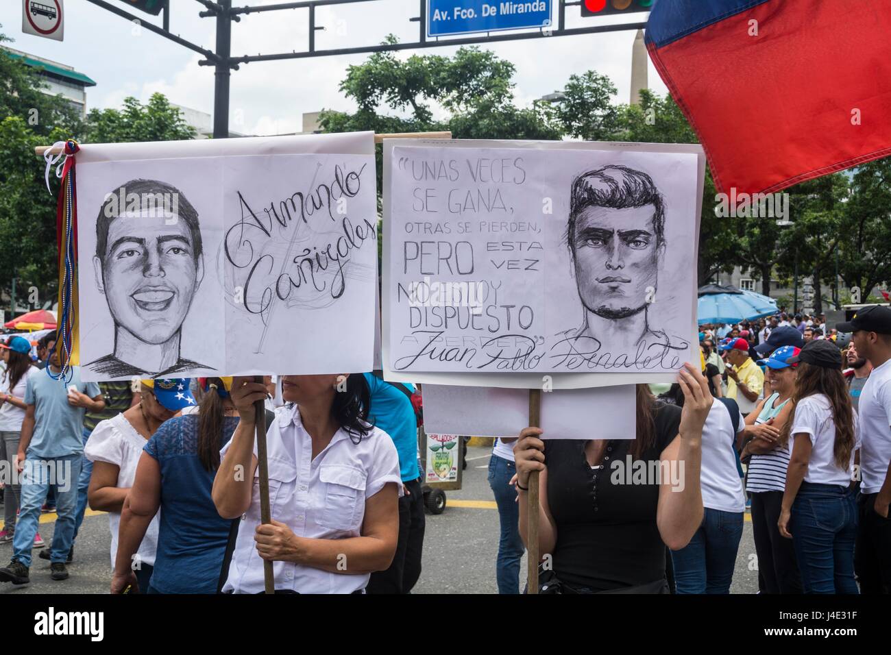 Two women carry drawings about Juan Pablo Pernalete and Armando Cañizales, young people recently killed in the protests, by firing tear gas directly on his body, by the Police and National Guard. MUD (Bureau of Unity) marches along with thousands of Venezuelans against the Constituent Assembly in Caracas. May, 8.2017 Stock Photo