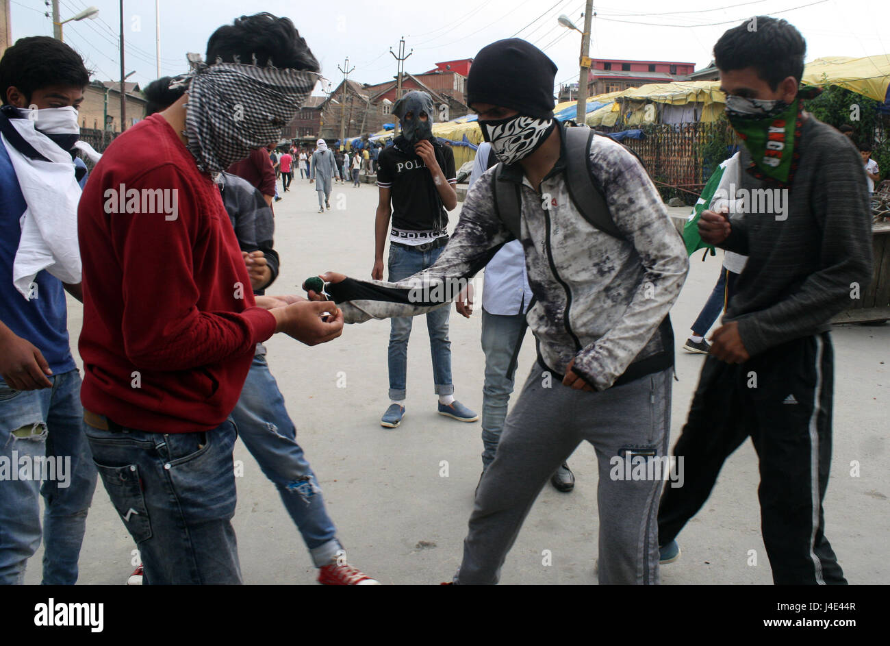 Srinagar, Kashmir. 12th May, 2017. Kashmiri protesters burn fire crackers before throwing at Indian police. Clashes broke out between protesters and security forces in downtown Nowhatta area of Srinagar. Groups of youth indulged in sloganeering and stone- pelting at Indian security forces soon after Friday congregational prayers. According to the report, 102 unarmed civilians were killed in 135 days of unrest that was sparked by the killing on July 8 of Hizbul Mujahideen commander Burhan Wani by the armed forces. Credit: sofi suhail/Alamy Live News Stock Photo