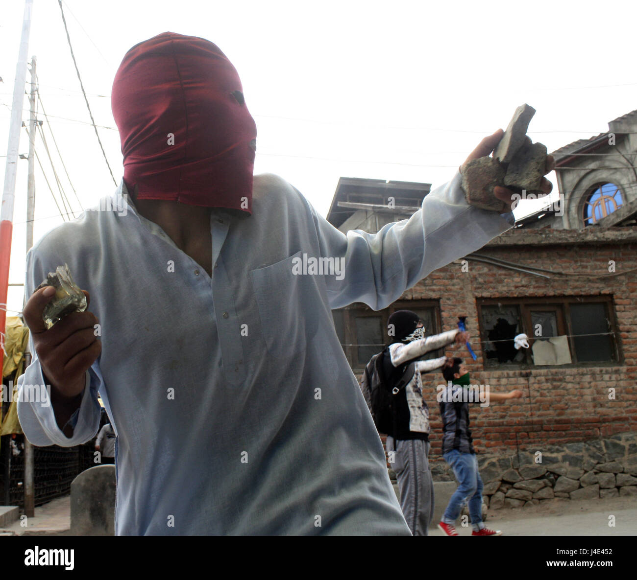 Srinagar, Kashmir. 12th May, 2017. .A Kashmiri protester throw bricks. Clashes broke out between protesters and security forces in downtown Nowhatta area of Srinagar. Groups of youth indulged in sloganeering and stone- pelting at Indian security forces soon after Friday congregational prayers. According to the report, 102 unarmed civilians were killed in 135 days of unrest that was sparked by the killing on July 8 of Hizbul Mujahideen commander Burhan Wani by the armed forces. Credit: sofi suhail/Alamy Live News Stock Photo