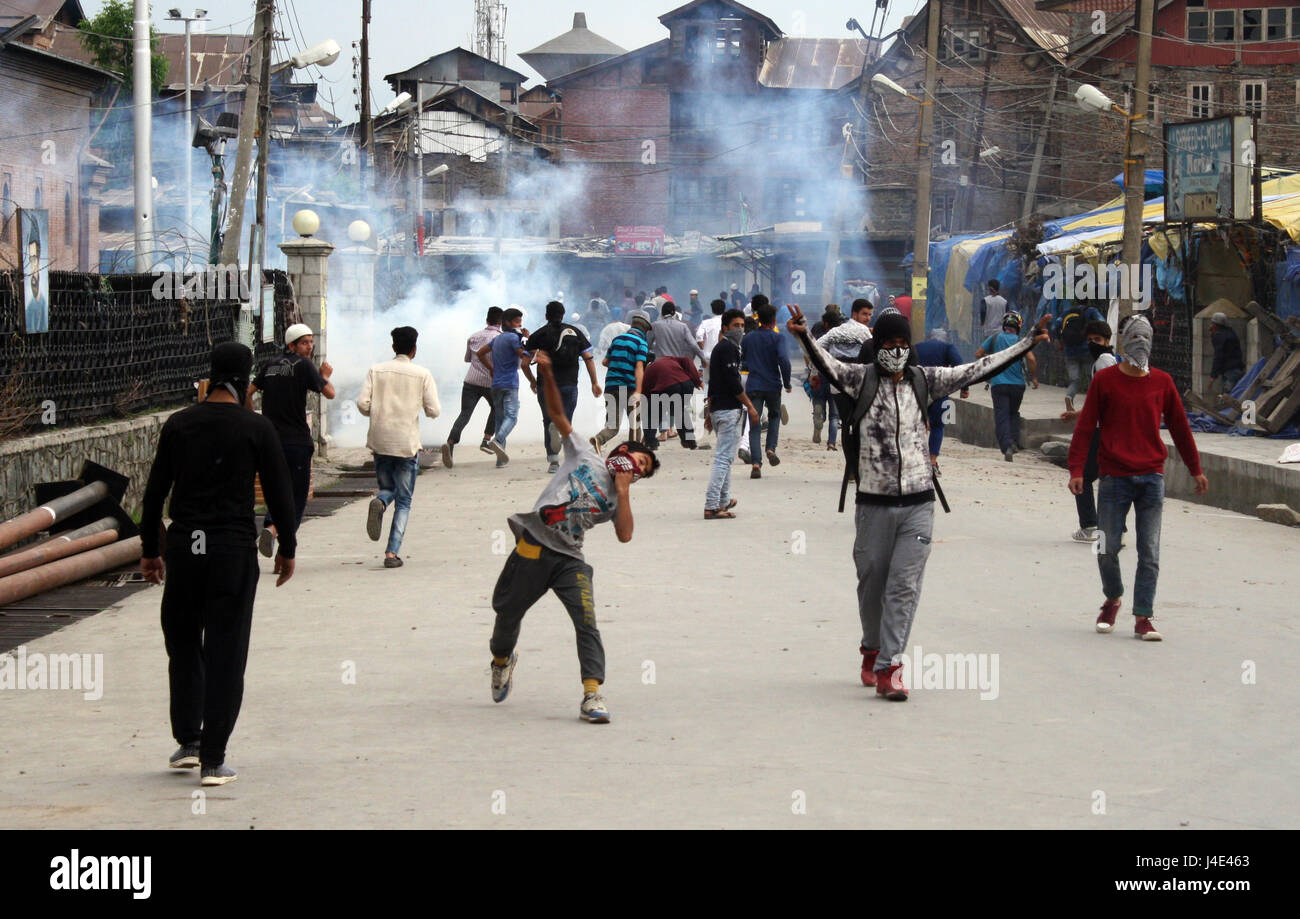 Srinagar, Kashmir. 12th May, 2017. Kashmiri protester throws bricks. Clashes broke out between protesters and security forces in downtown Nowhatta area of Srinagar. Groups of youth indulged in sloganeering and stone- pelting at Indian security forces soon after Friday congregational prayers. According to the report, 102 unarmed civilians were killed in 135 days of unrest that was sparked by the killing on July 8 of Hizbul Mujahideen commander Burhan Wani by the armed forces. Credit: sofi suhail/Alamy Live News Stock Photo