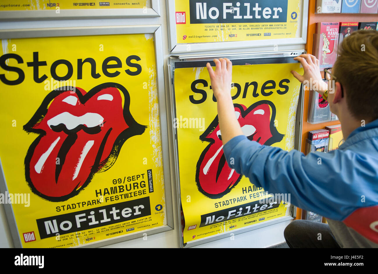 Hamburg, Germany. 12th May, 2017. ILLUSTRATION - An employee of a ticket  shop sticks a poster for the tour of the Rolling Stones to a wall in Hamburg,  Germany, 12 May 2017.