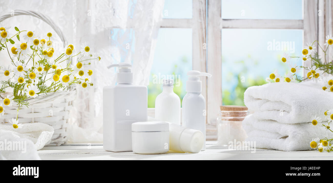 White towel and cosmetic dispensers on window background Stock Photo