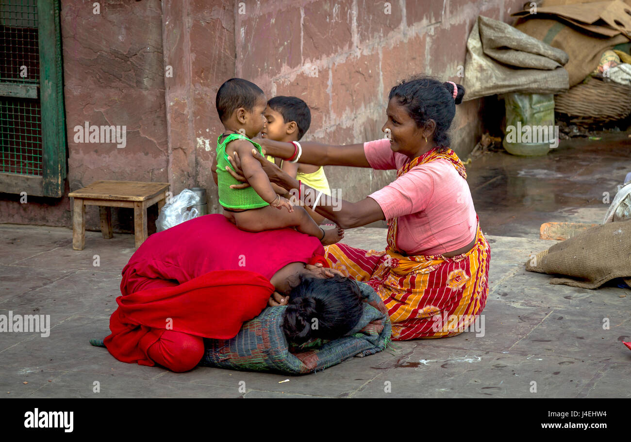 Happiness in poverty. A mother caresses her baby girl child on a street pavement at Kolkata, India. Stock Photo