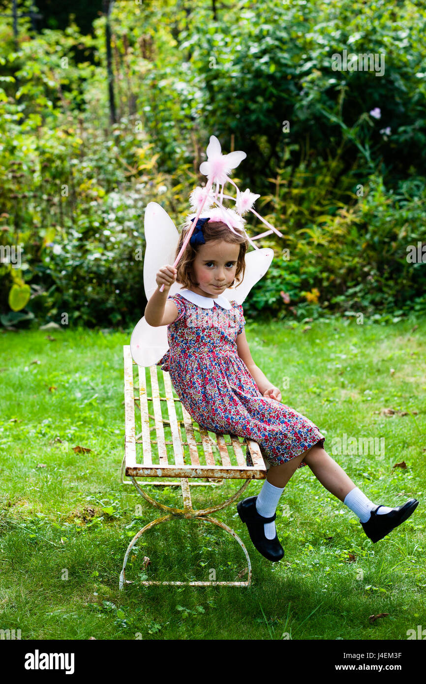 Dressing up - a girl plays as a fairy in the English summer garden Stock Photo