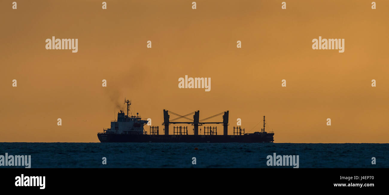A cargo ship on the horizon off the coast of Gladstone, Queensland. Stock Photo