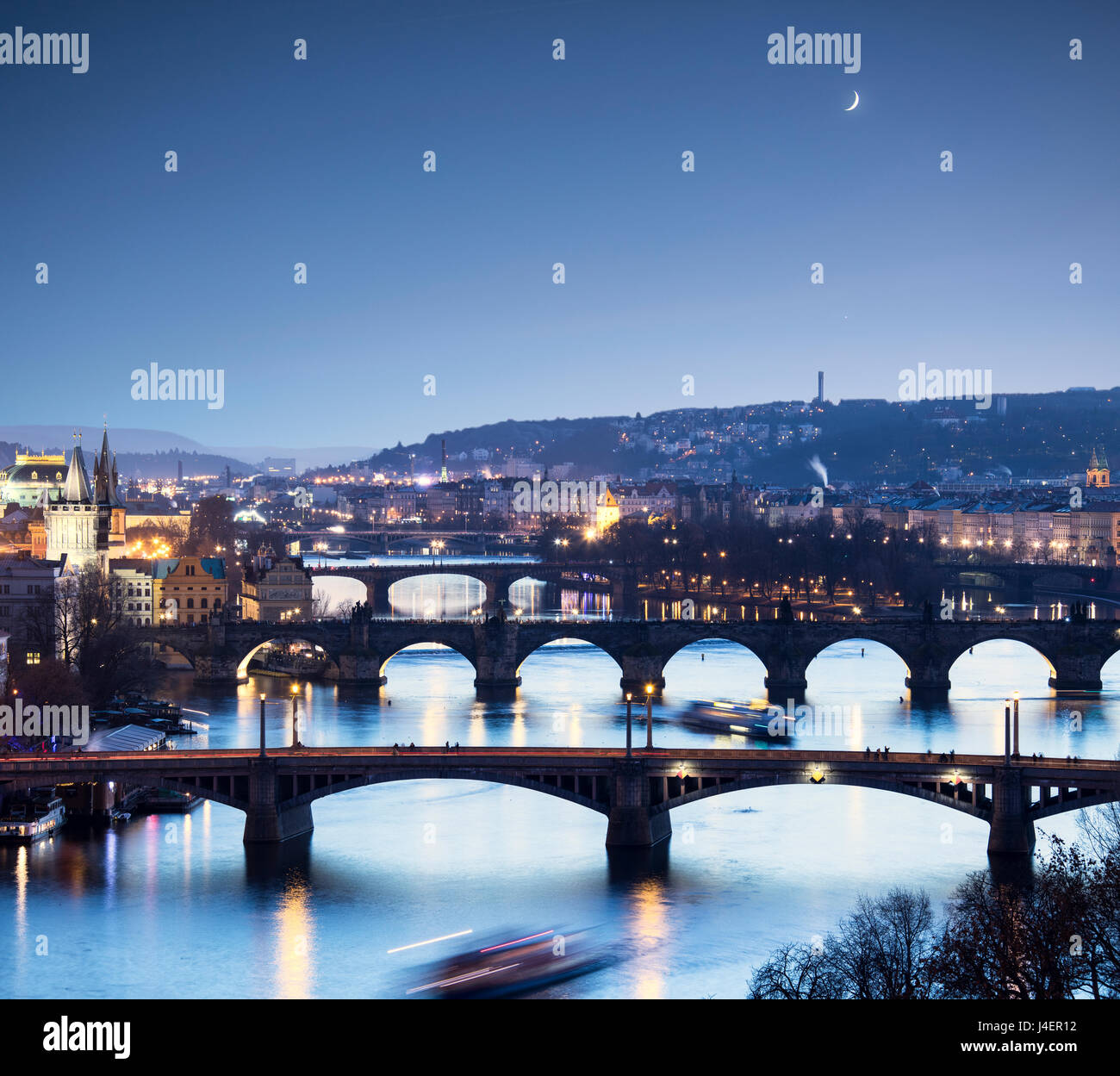 Dusk lights up the historical bridges and buildings reflected on Vltava River, Prague, Czech Republic, Europe Stock Photo
