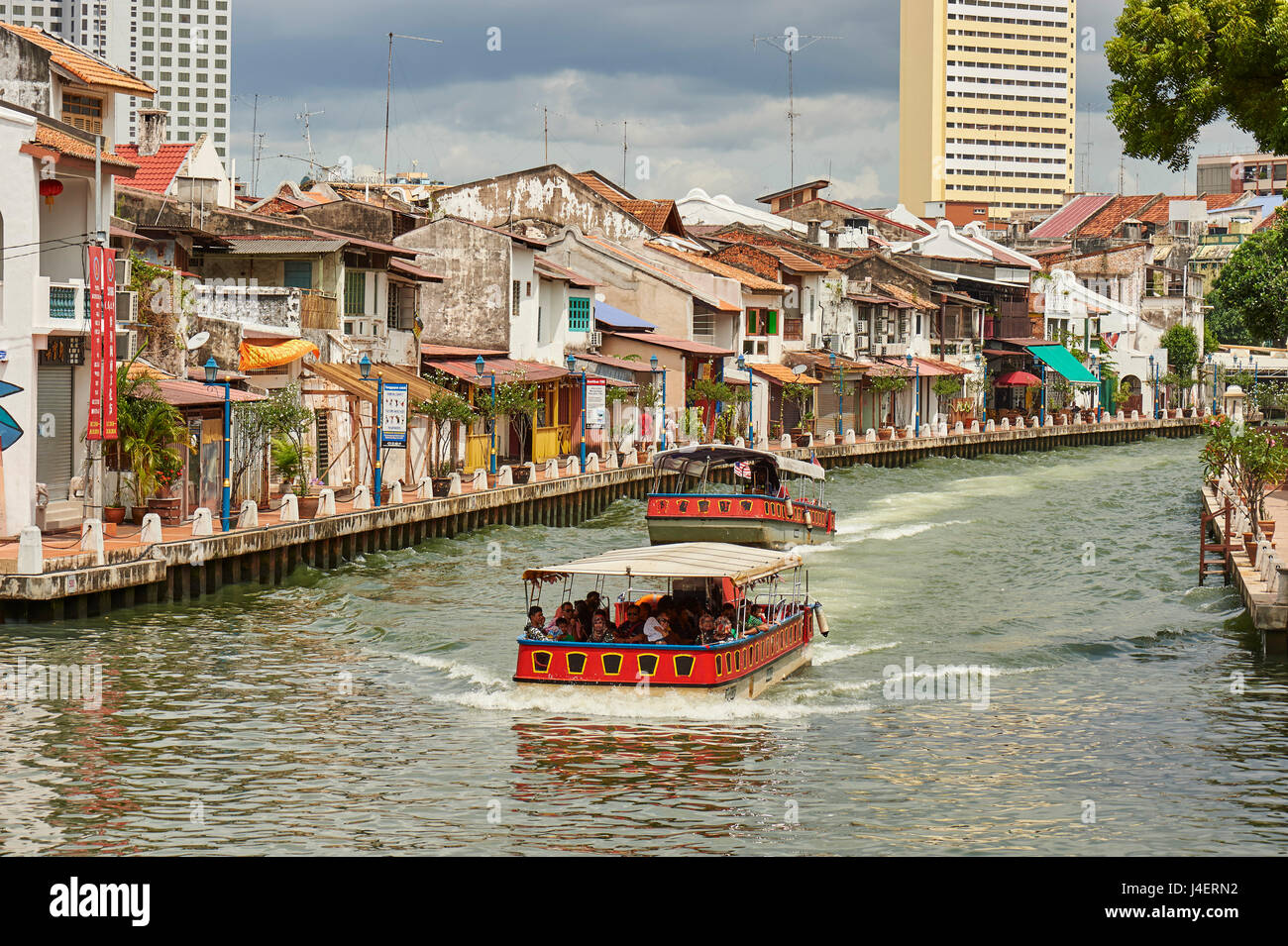 Pleasure boats pass by Chinatown on the Malacca River, Malacca, Malaysia, Southeast Asia, Asia Stock Photo