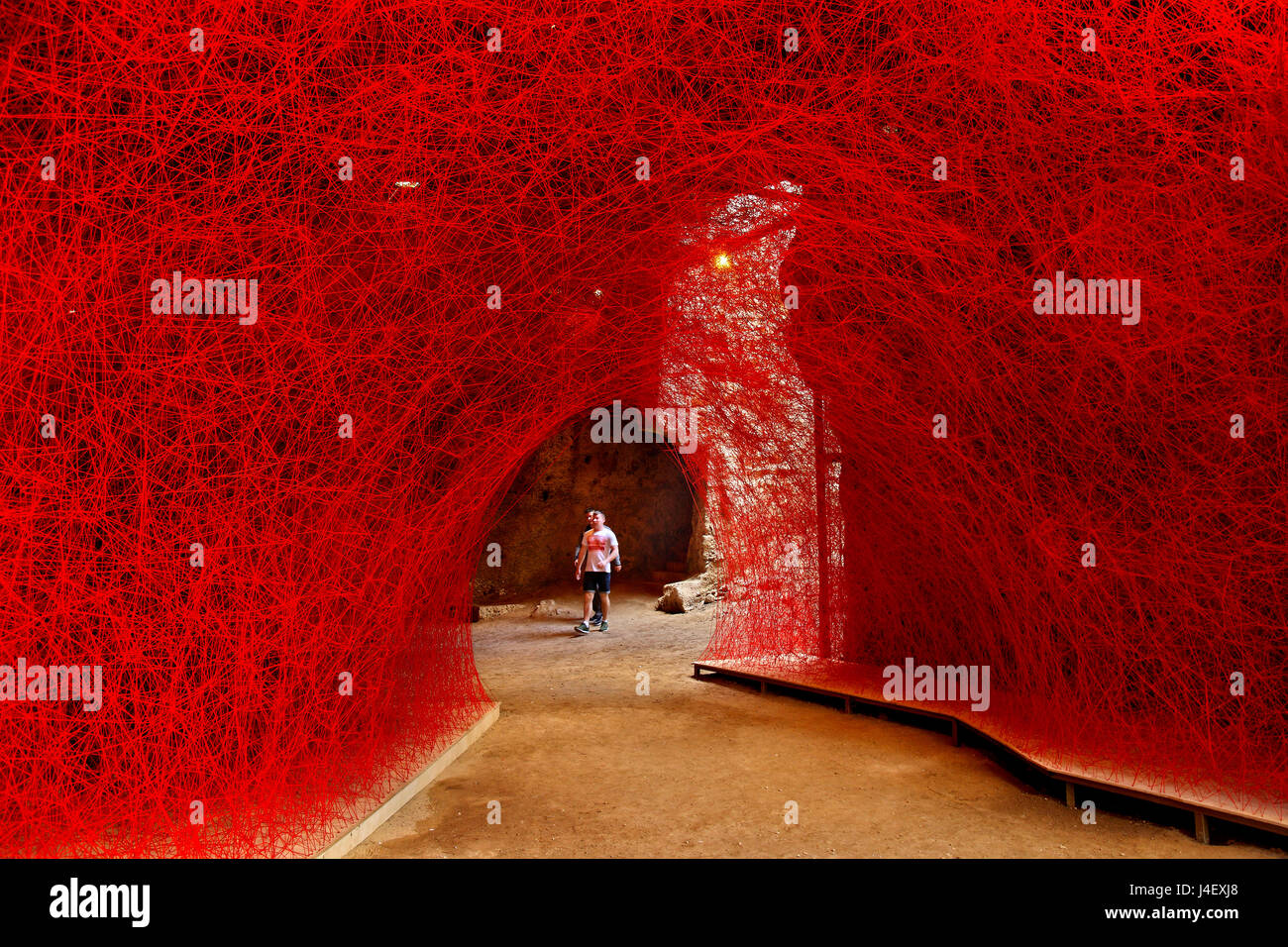 'A walk through the line' artistic installation by Chiharu Shiota in a cave of Fabrica, Paphos, Cyprus. Stock Photo