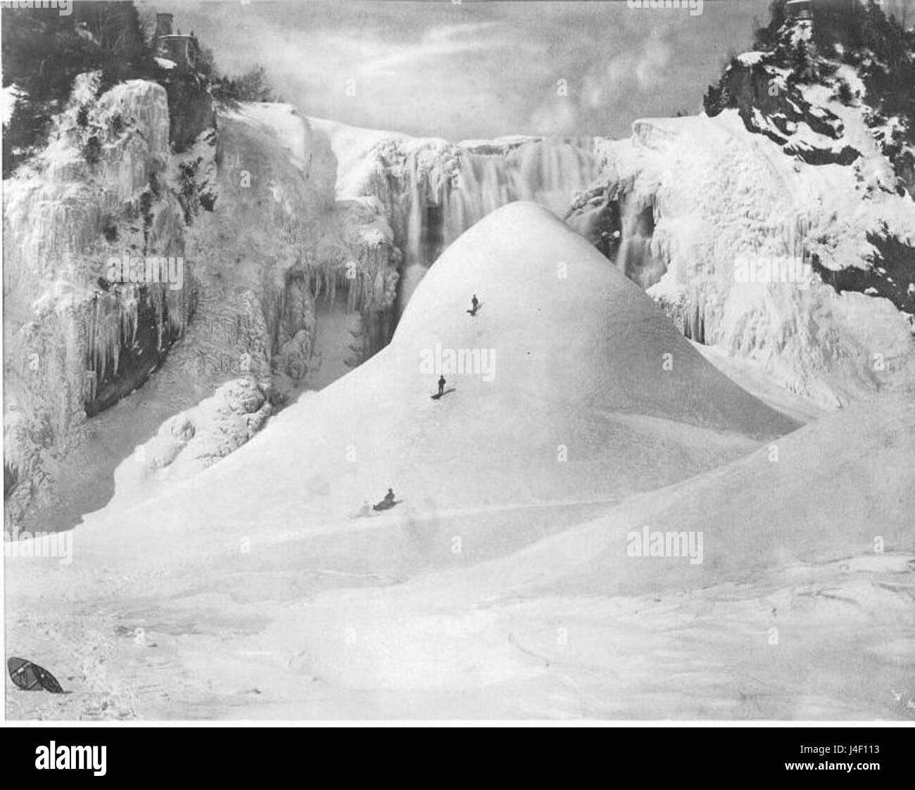 This 1876 photograph by Alexander Henderson captures the iconic ice cone at Montmorency Falls in Quebec, Canada. The image highlights the dramatic ice formation that forms at the base of the falls during winter. Stock Photo