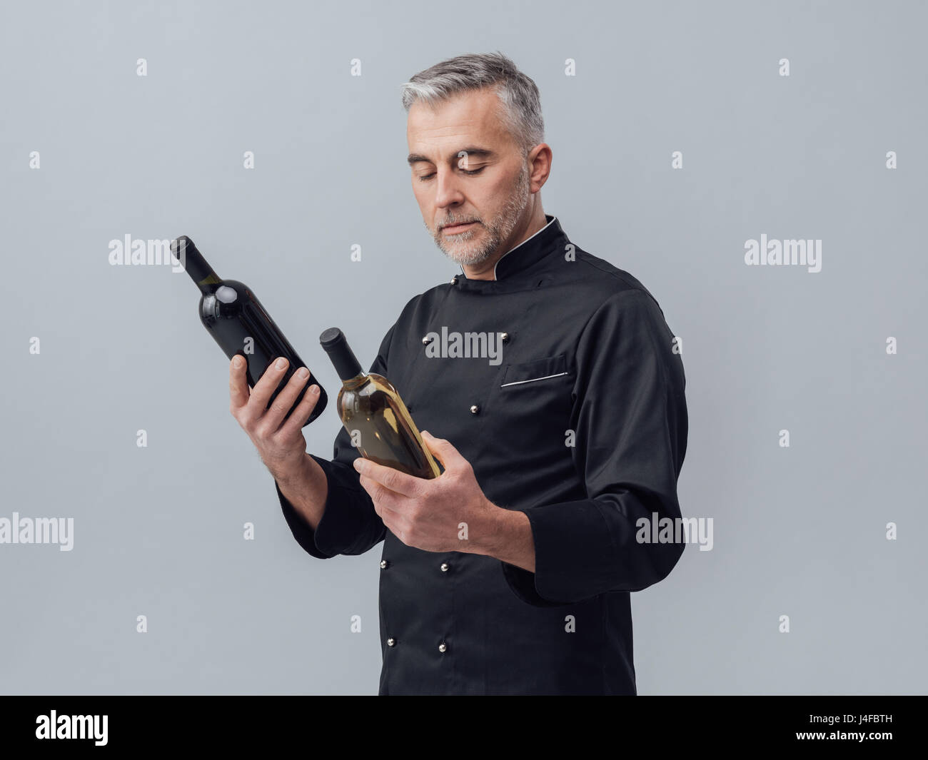 Professional chef and wine expert comparing wine bottles and reading