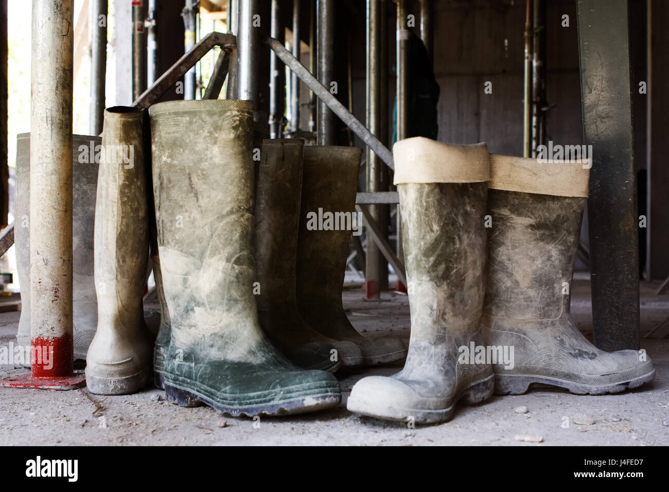 Dirty galoshes (rubber boots) at a construction site. Stock Photo