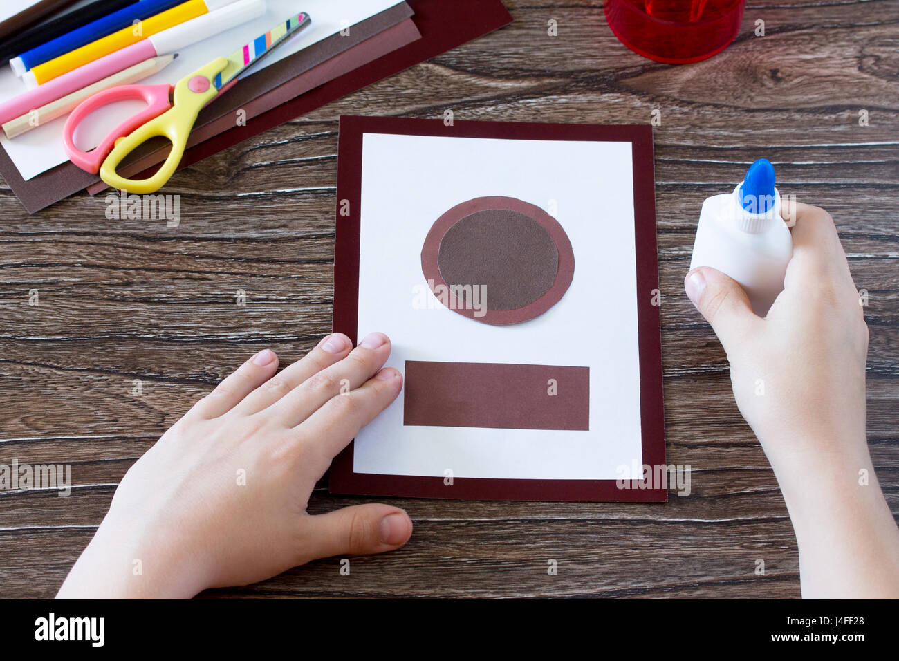 The child glues the parts. Greeting Card guitar music. Children's art