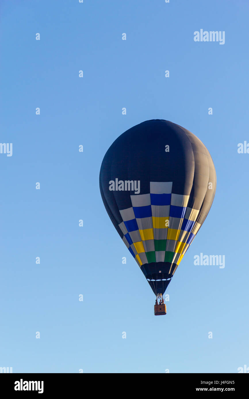 Colored hot air balloon flying in a blue sky Stock Photo - Alamy