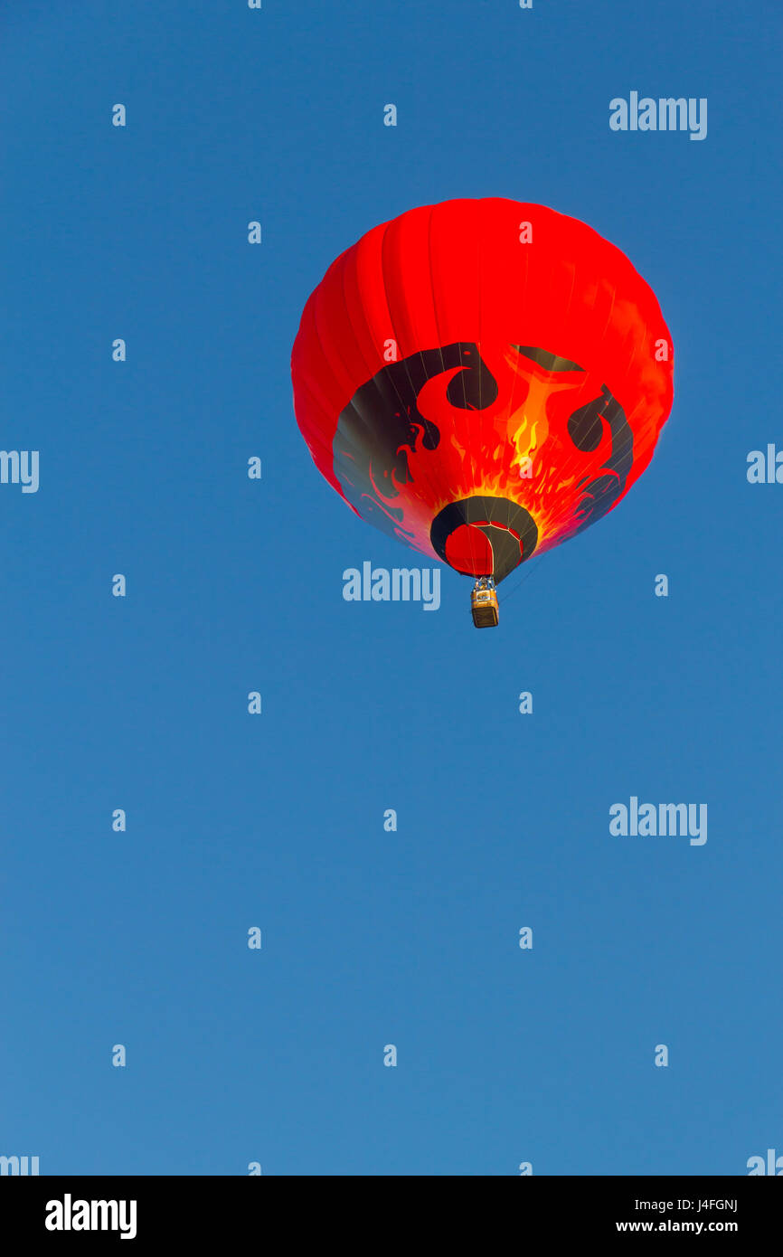 Colored hot air balloon flying in a blue sky Stock Photo - Alamy