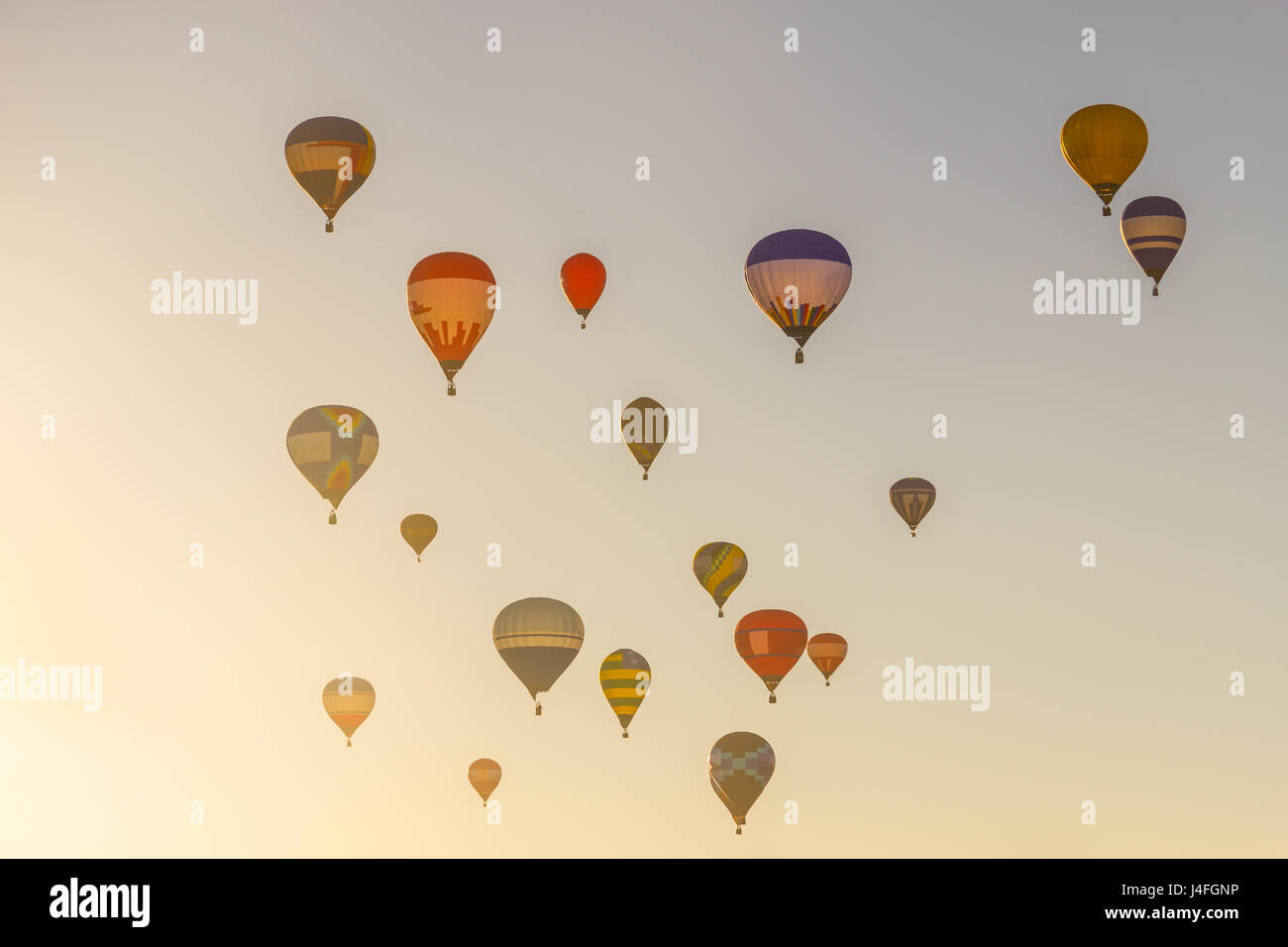 Group of Colored hot air balloons flying in a blue sky in the sunset ...