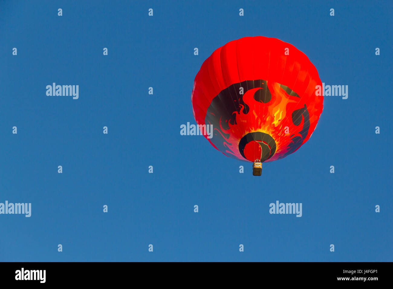 Colored hot air balloon flying in a blue sky Stock Photo - Alamy