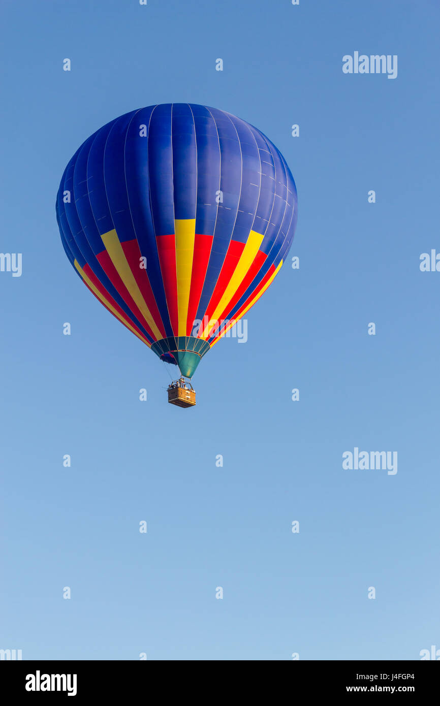 Colored hot air balloon flying in a blue sky Stock Photo - Alamy